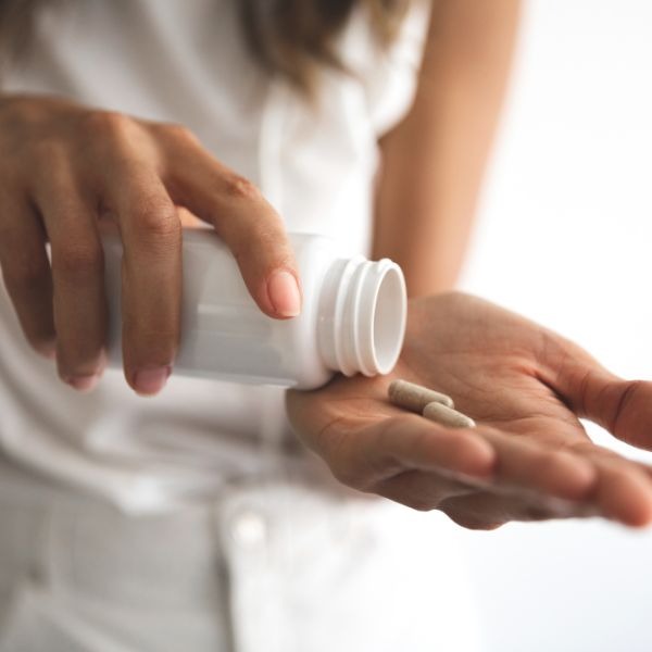 a woman holding a pill bottle