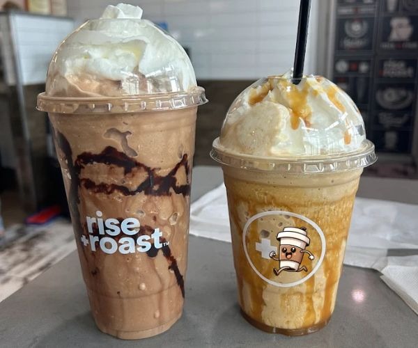 two cups of coffee and a drink in a coffee shop