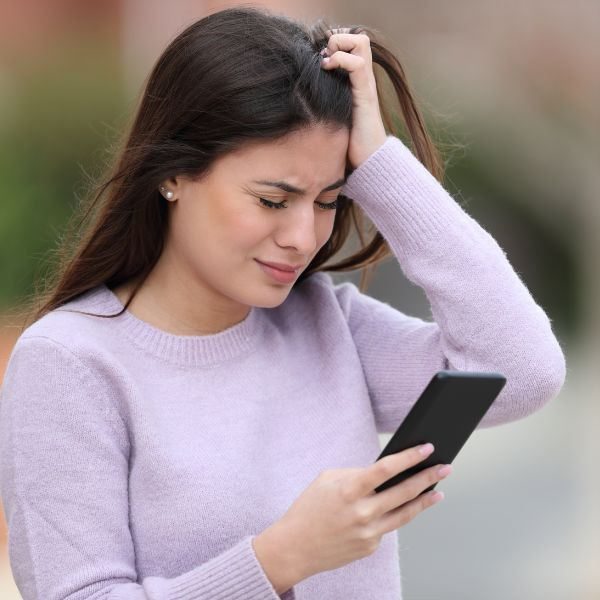 a woman in a purple sweater holding a cell phone
