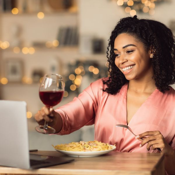a woman sitting at a table with a glass of wine