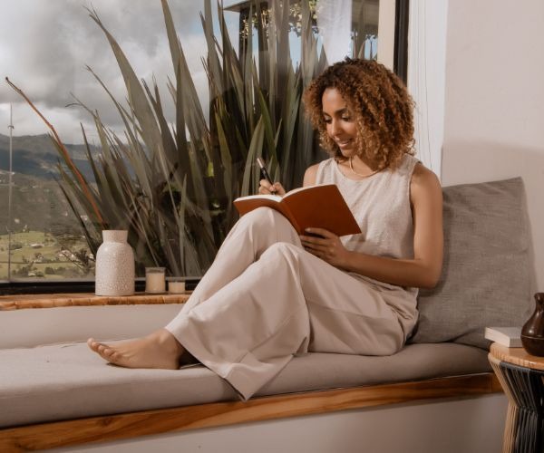 a woman sitting on a couch reading a book