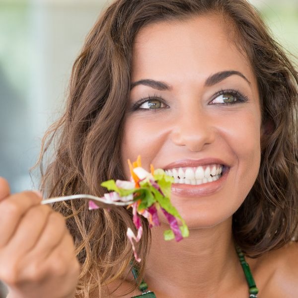 a woman eating a salad with a fork