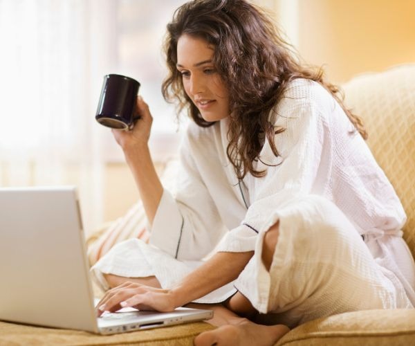 a woman sitting on a couch with a cup of coffee