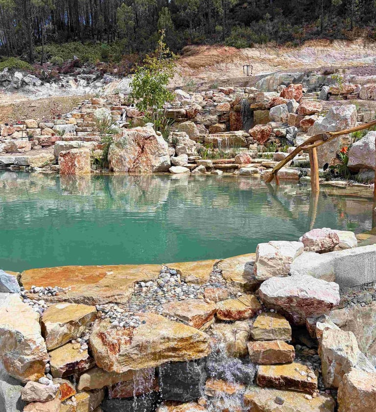 Natural pool waterfall with stream flowing through wetland into limestone swimming area - Aqua Vitae