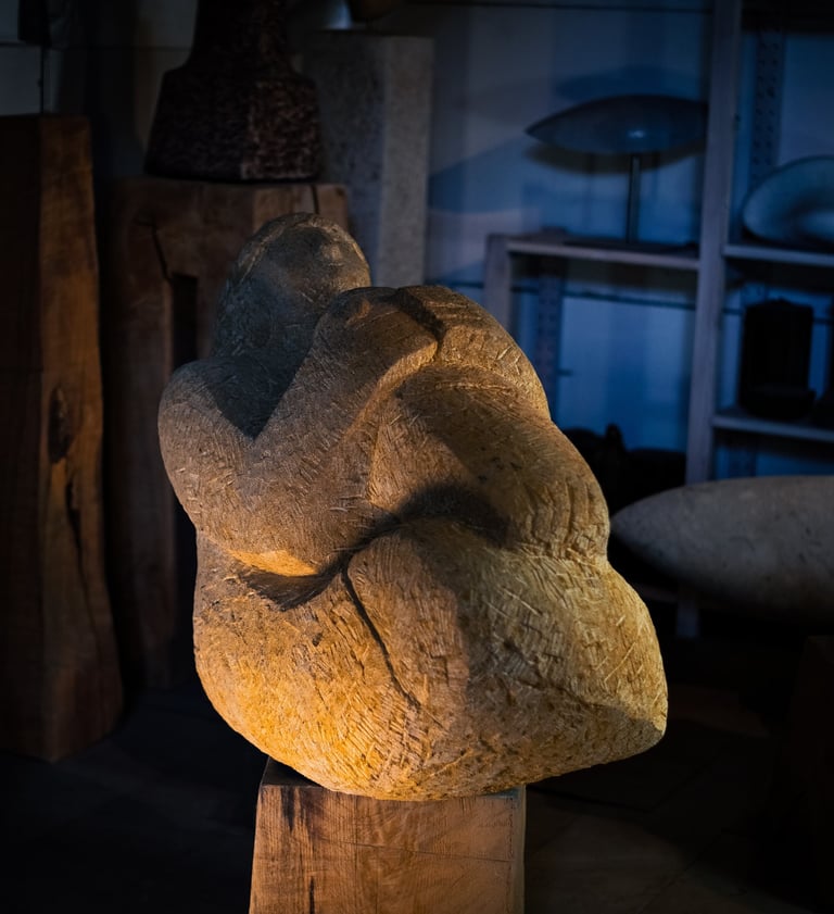 Frauenskulptur aus Stein, liegend, mit angezogenen Knien