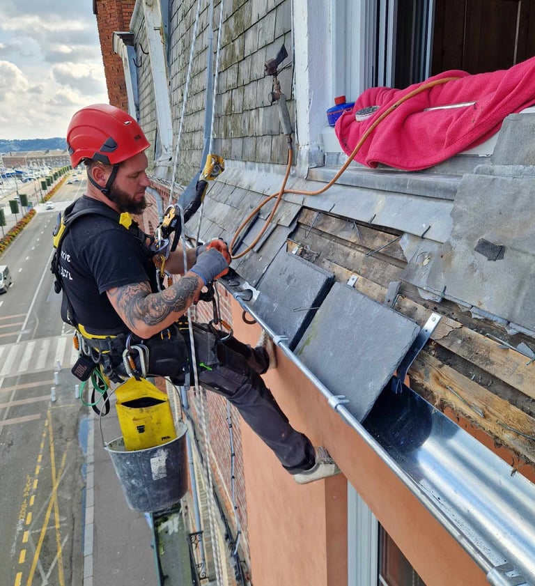 cordiste couvreur sur façade immeuble