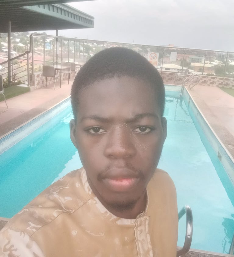 a young man standing in front of a swimming pool