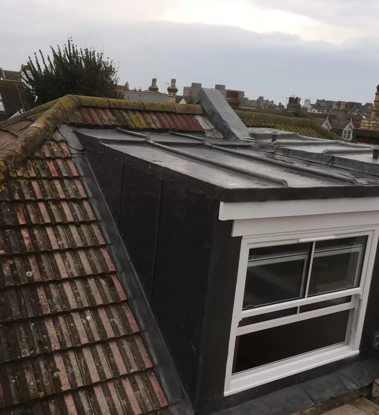 Loft conversion with dormer window added to roof of Brighton home.