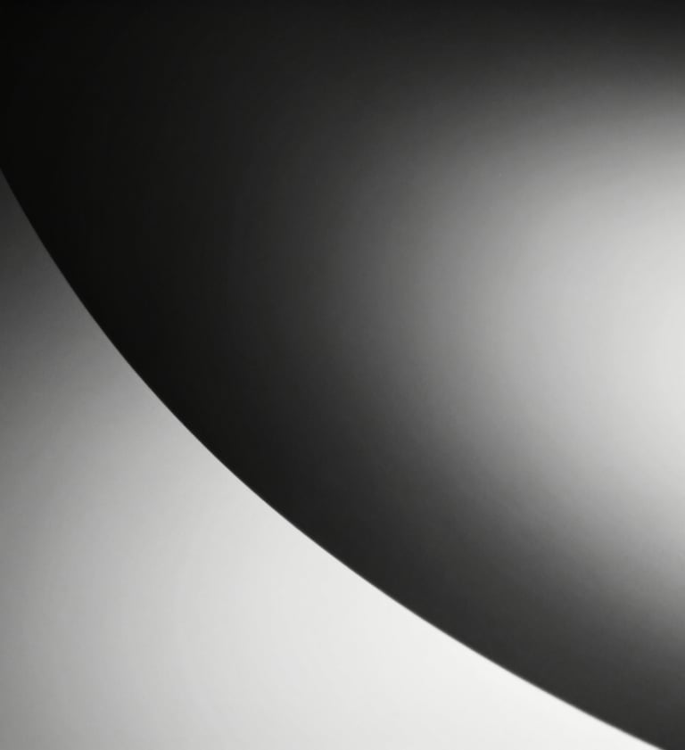 Abstract black and white macro photography of light hitting a curved surface, creating a smooth gradient from deep charcoal black to pure white, high-craft feel.