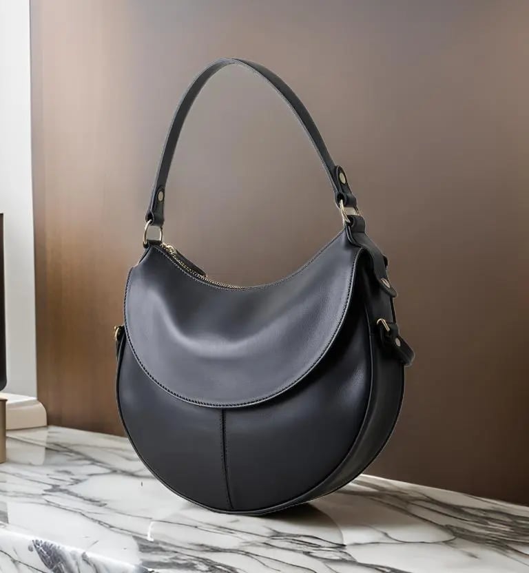 A stylish, curved black leather handbag, crafted with precision and designed for modern living.