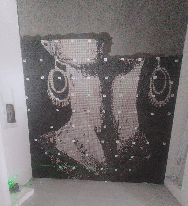 Präzise Anbringung eines Glasmosaiks mit Hilfe eines Lasers für perfekte Ausrichtung.