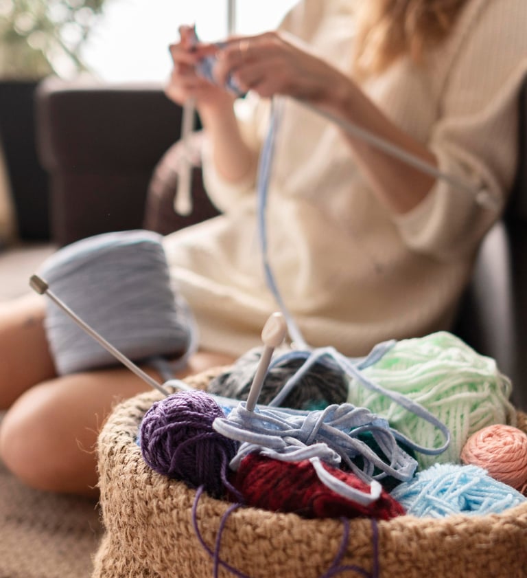 mujer sentada tejiendo un proyecto con trapillo azul cielo