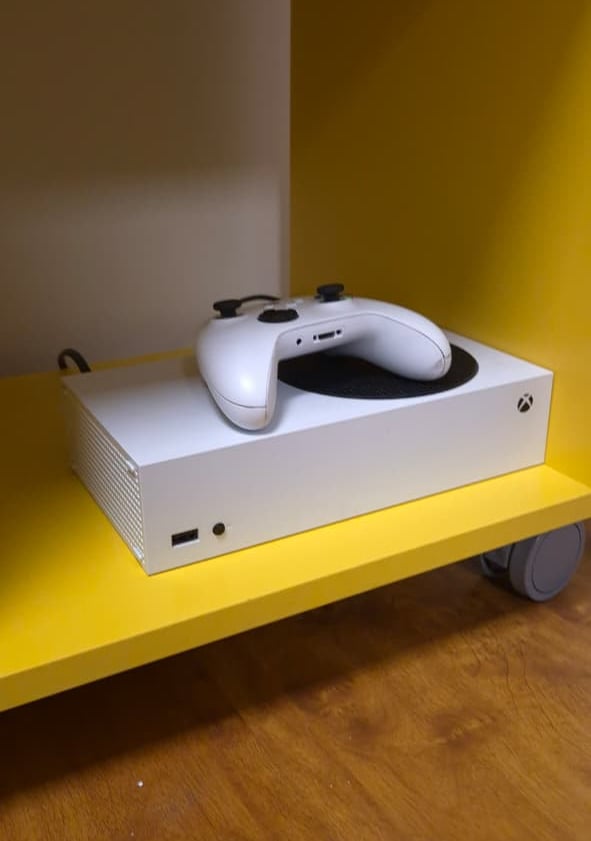a turntable with a white controller and a yellow shelf