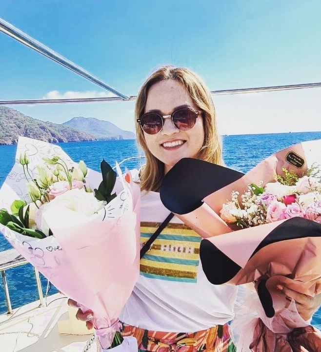 a Japanese woman holding a bunch of flowers on a boat
