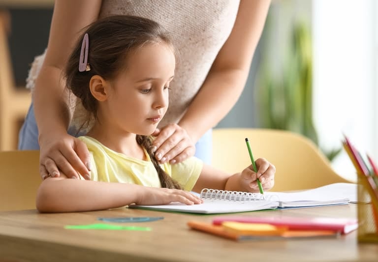 enfant en difficulté aidée par un adulte