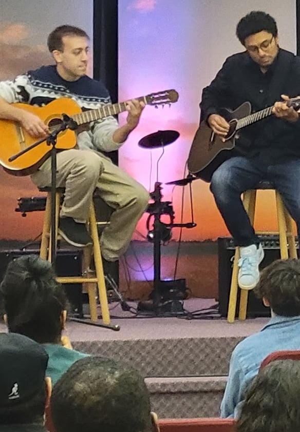 Two young men playing guitar on stage