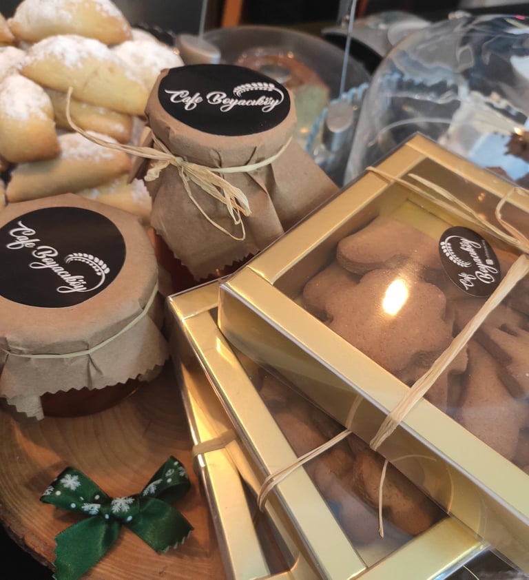 üzerinde cafe boyacıköy logosu bulunan zencefilli kurabiye dolusu kutular var ev yapımı reçel kavanozları