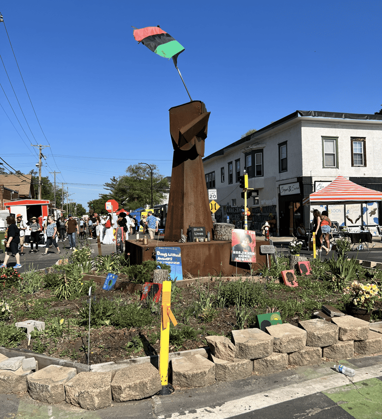 A metal fist sculpture with a Pan-African flag at a street memorial for George Floyd in Minneapolis.