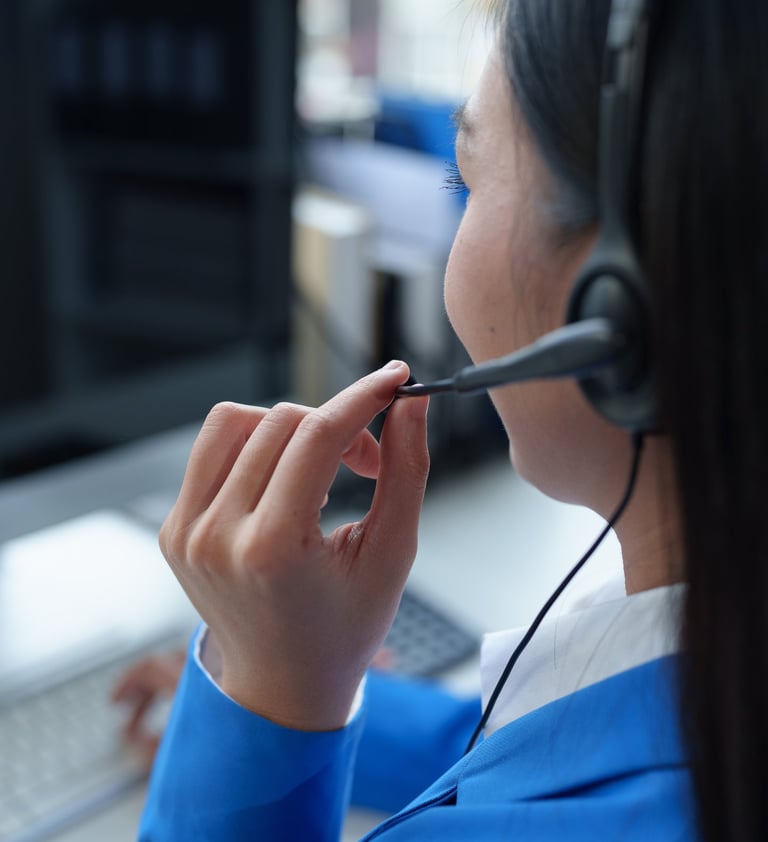 Mulher de costas com fone de ouvido e microfone fazendo atendimento ao cliente
