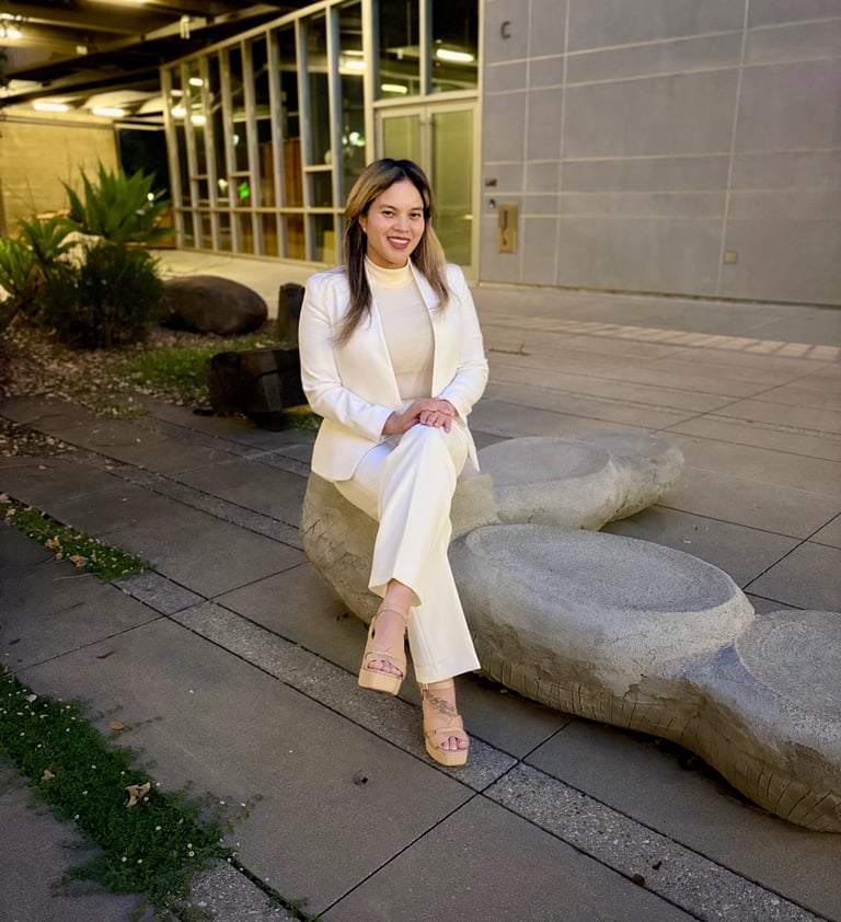 a female doctor in a whitecoat sitting in nature looking professional and friendly