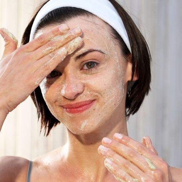woman exfoliating her face