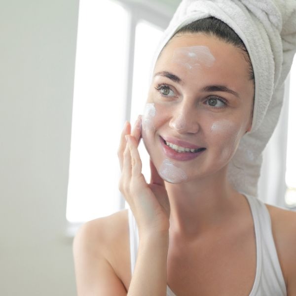 woman putting sunscreen on her face