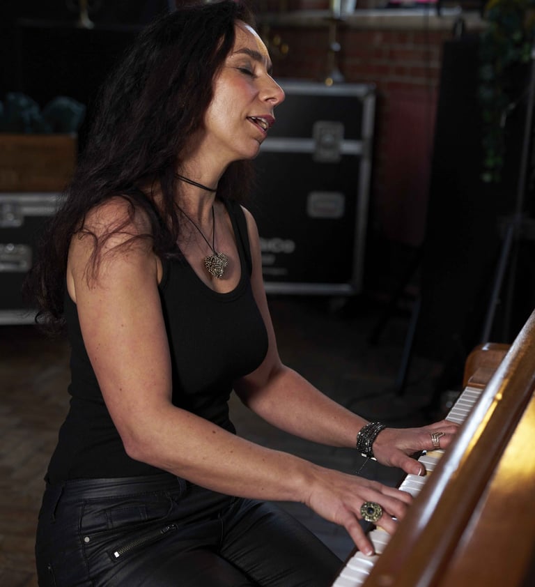 Helen Spooner playing piano on an antique piano, creating elegant live music.