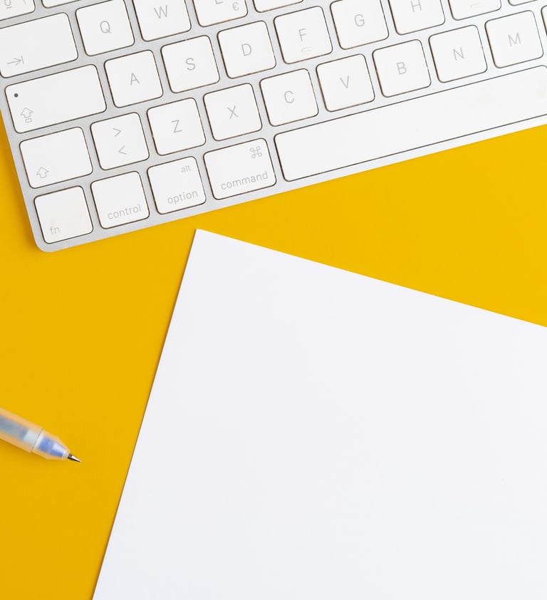 A White Keybord, Pen, and Sheet of Paper on Yellow Background