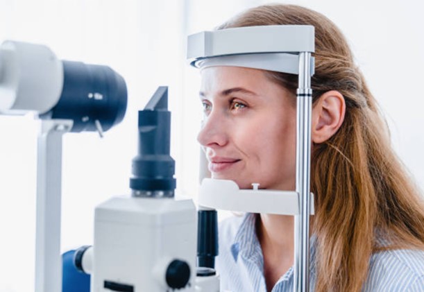 a woman is looking through a microscope at a doctor