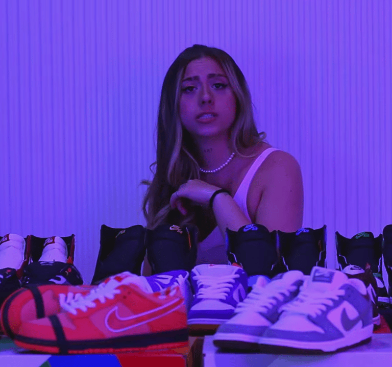 a woman standing in front of a table with a lot of shoes