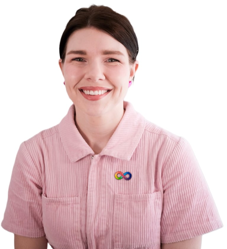 A photo of Frances, Occupational Therapist smiling and wearing a pink jumpsuit & neurodiversity pin