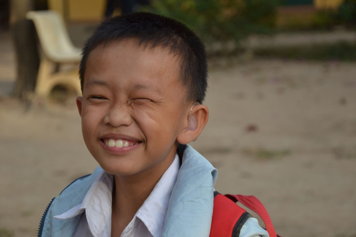 a young boy with hearing aid on his head