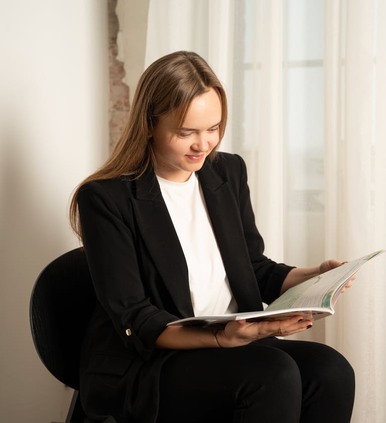 moteris sėdi ir skaito anglų kalbos vadovėlį anglų kalbos kursų metu