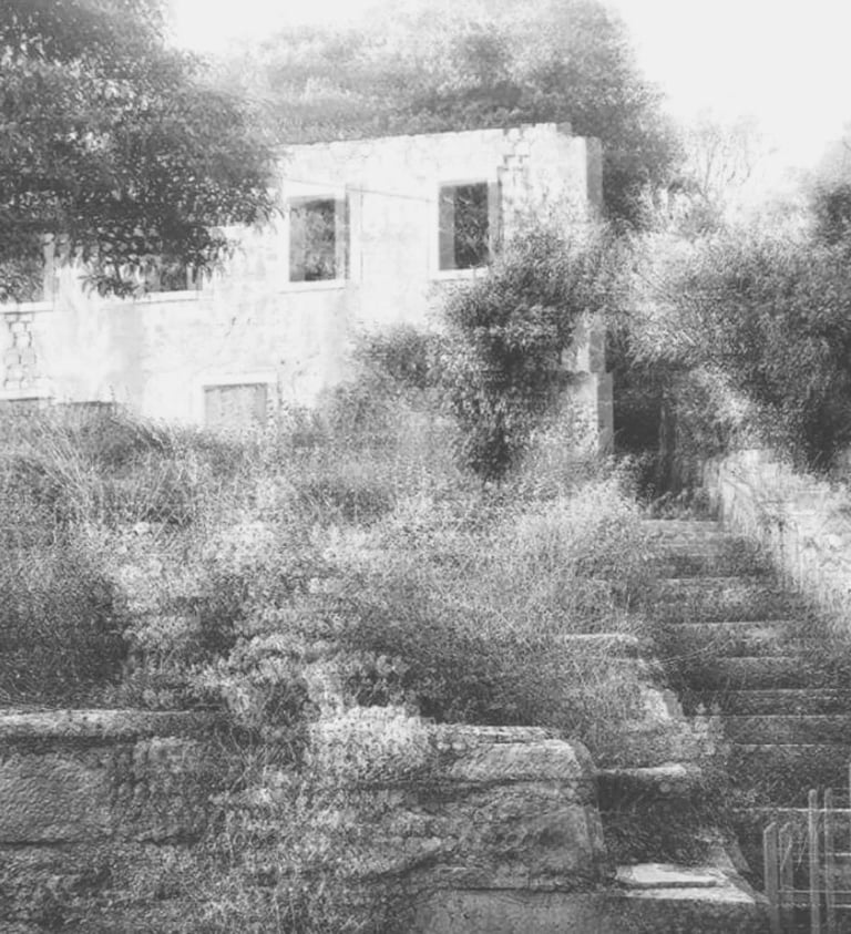 Black and white photograph of an abandoned stone house and overgrown stairs, used as a research header by artist Tina Bikic.