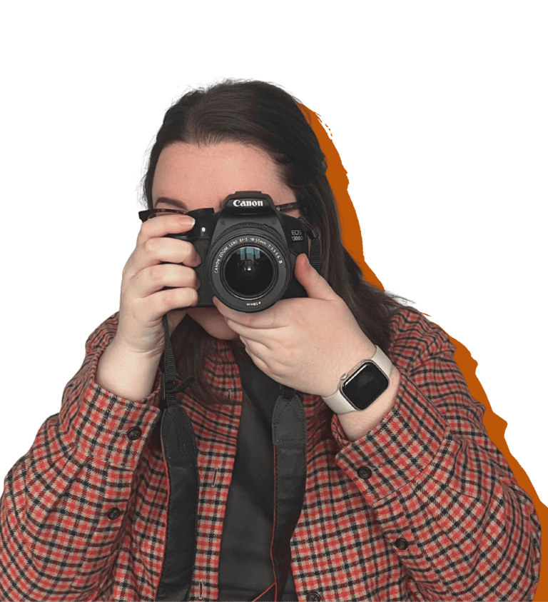 A women (Erin, owner of EB Socials) pointing a canon camera at the camera