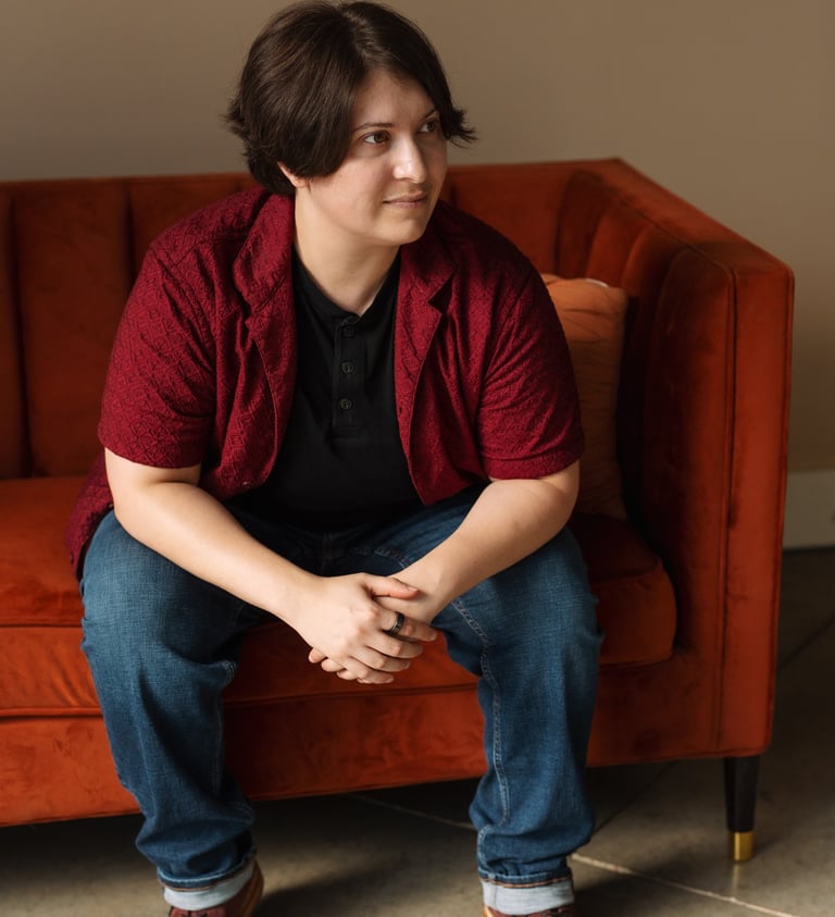 Photo of Rashad McAllister sitting on a couch and listening to someone off camera