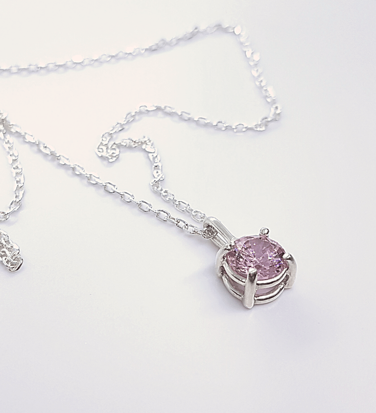 a necklace with a pink crystal pendant on a chain
