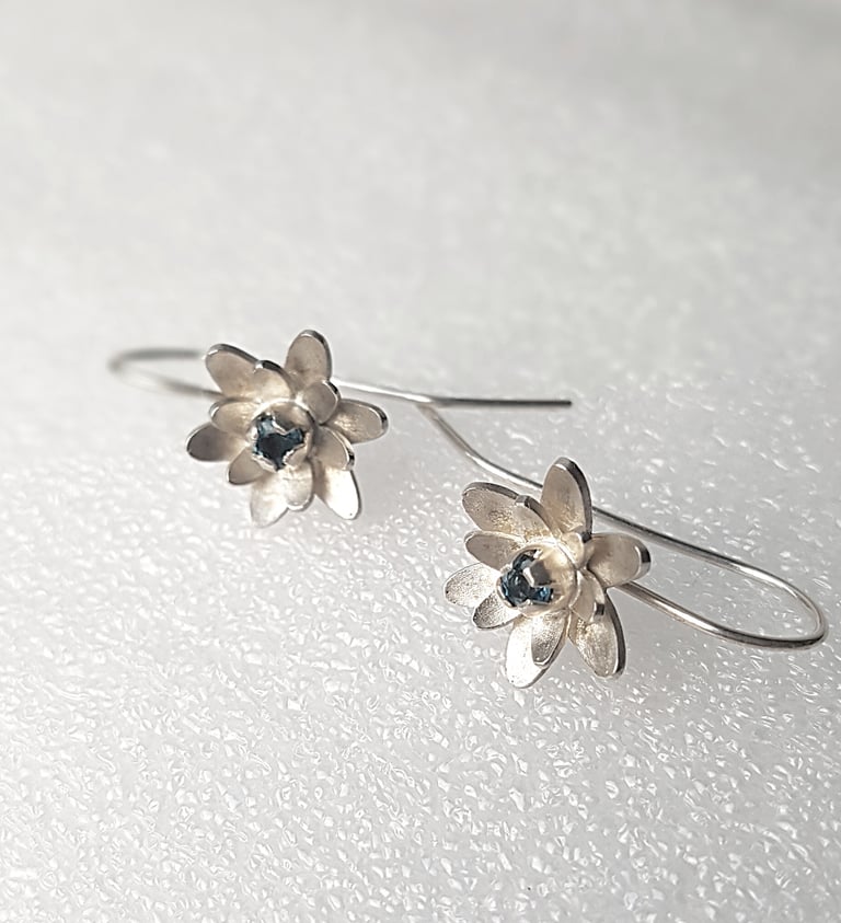 a pair of earrings with a flower design