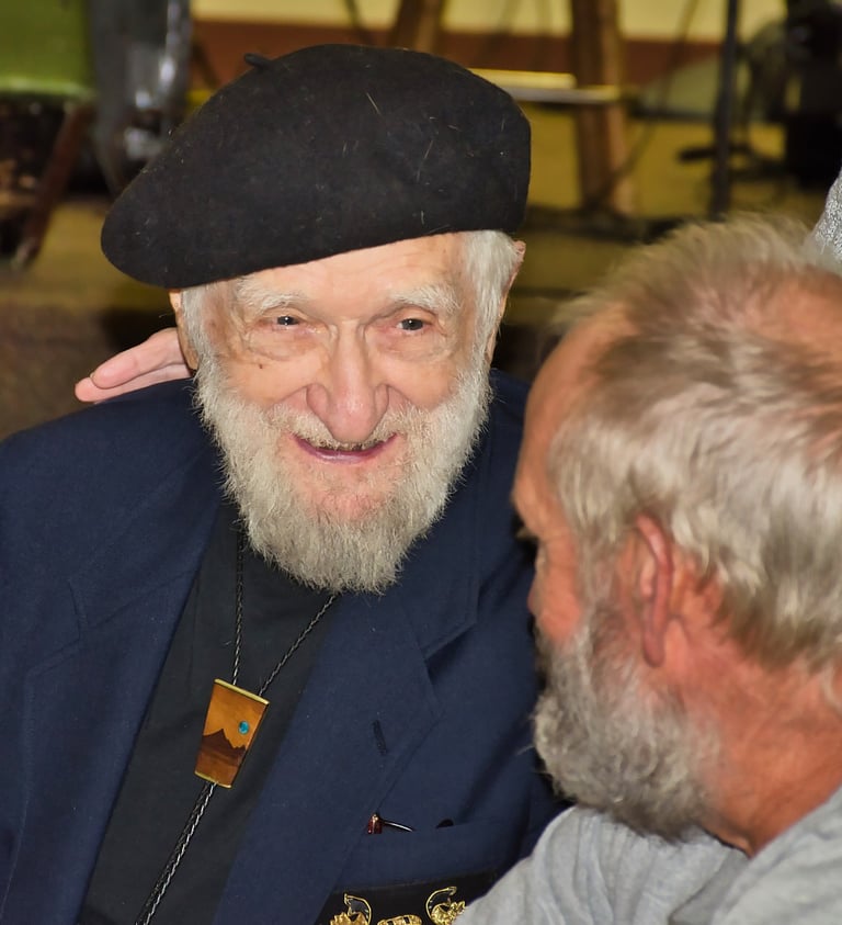a man with a white beard and a hat smiling at his friend