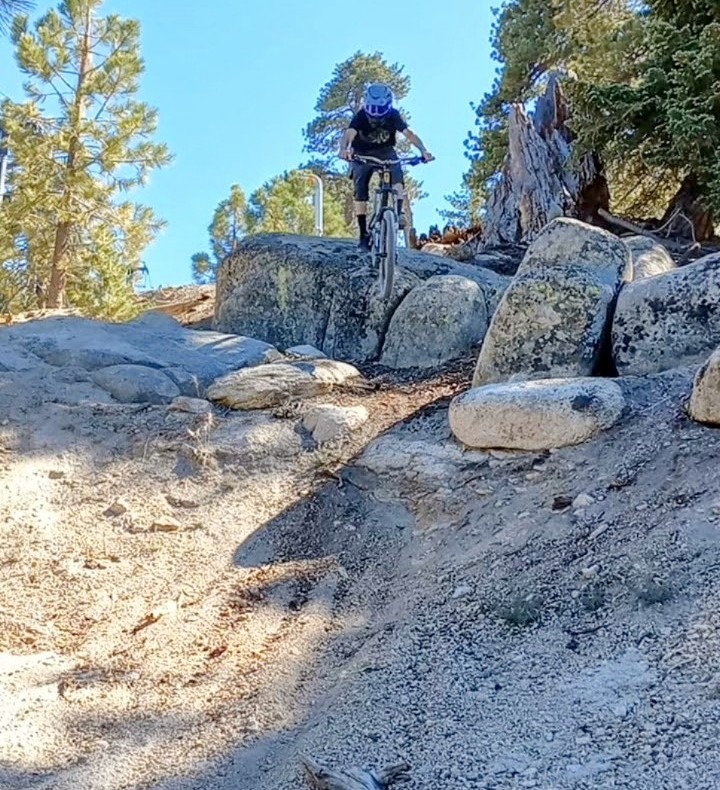 Mountain biker riding rocky terrain at Snow Valley bike park in Running Springs California on loose 