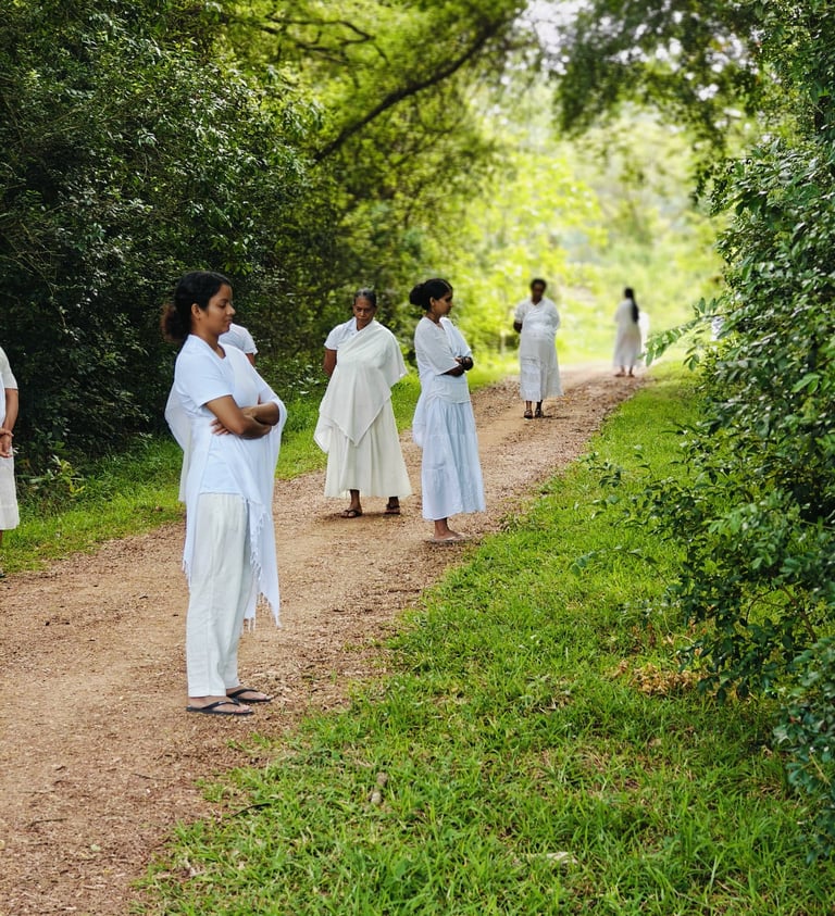 a group of people in white dresses walking down a path