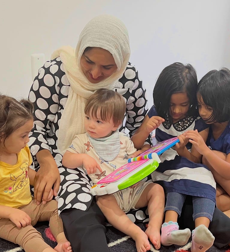 Caregiver and children reading an electronic book at daycare