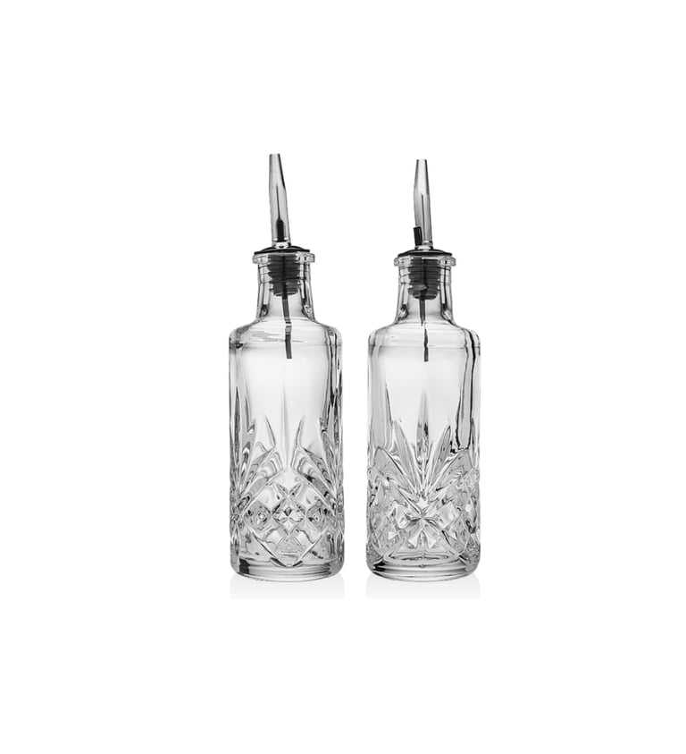 Pair of elegant cut glass bitters bottles with stainless steel pourers for craft cocktails.