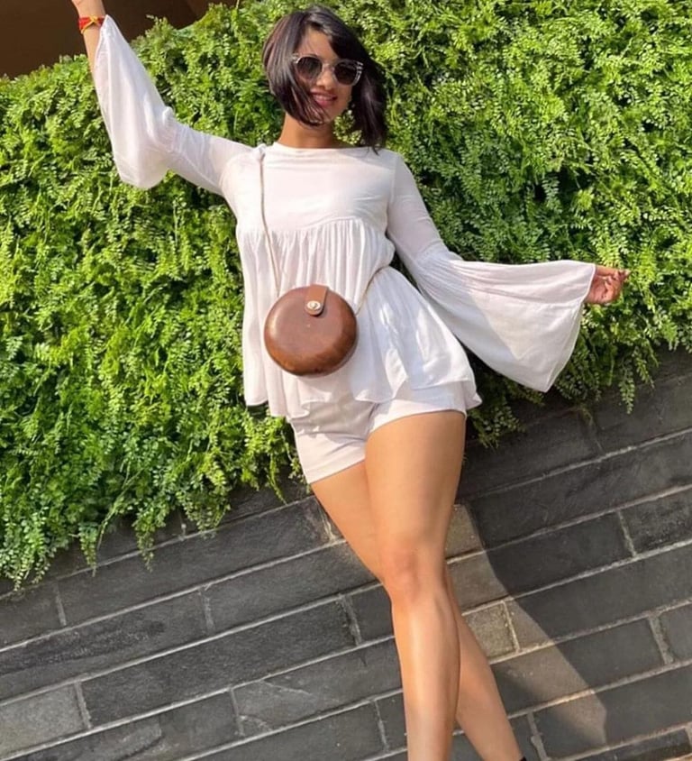 a woman in a white dress and sunglasses