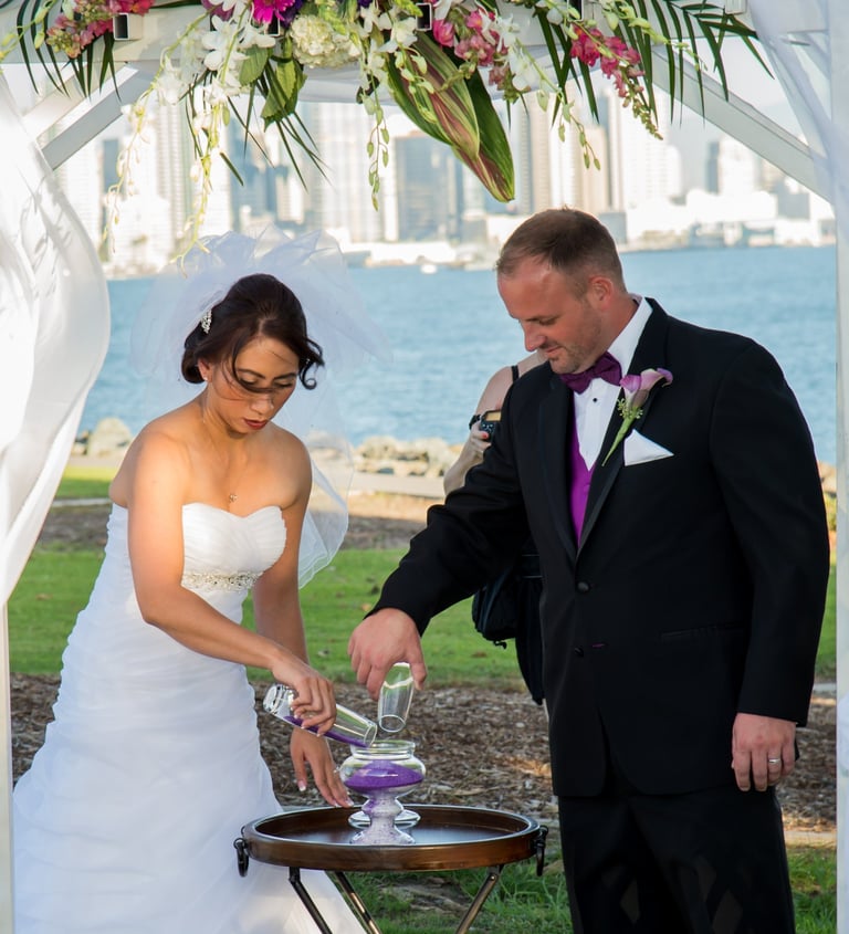 couple pouring sand for sand ceremony, wedding at Harbor Island park overlooking San Diego skyline