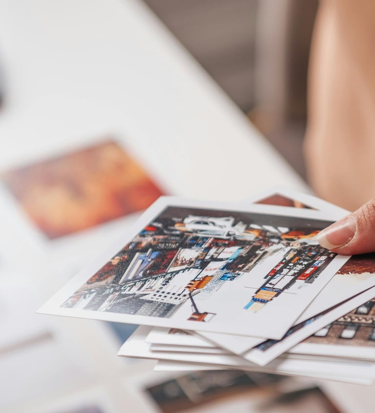 a person holding a bunch of photos doing a choice for the creation of a unique luxury print