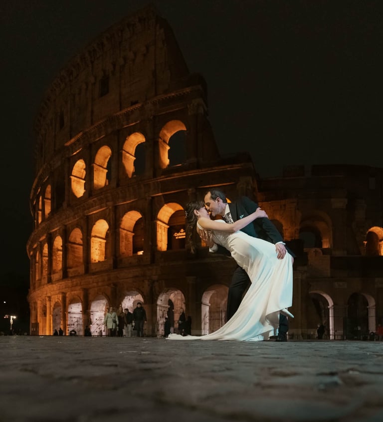 "Pareja heterosexual casada besándose frente al Coliseo en Roma, celebrando su boda y su amor."