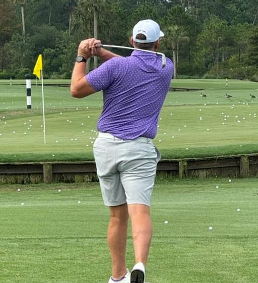 Men’s performance golf polo in purple on golf course