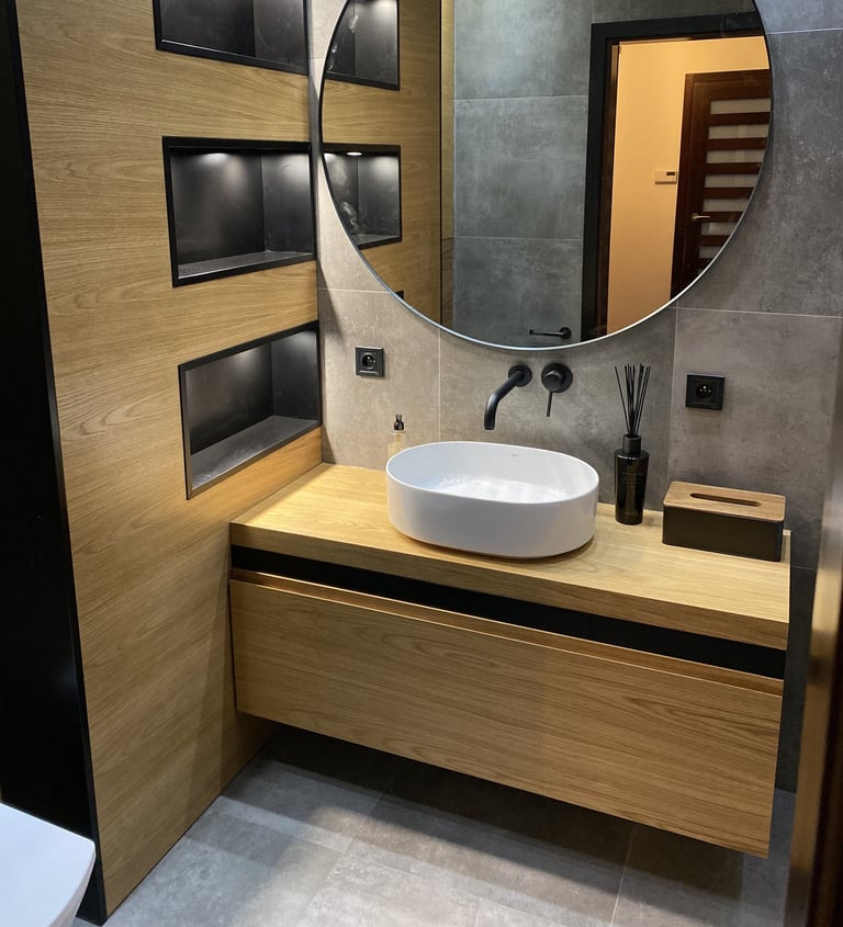 a bathroom with a large round mirror and a sink