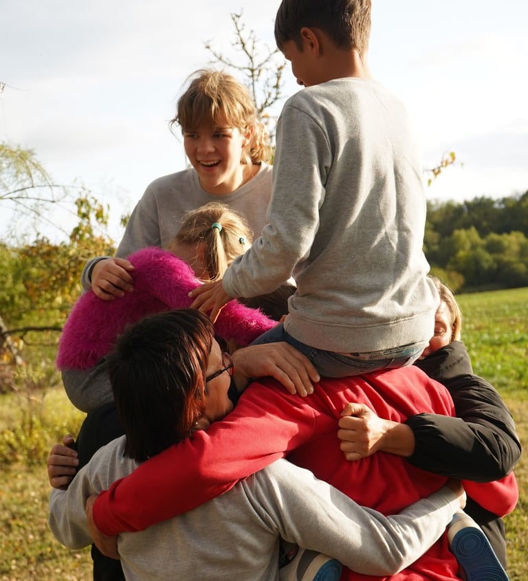 Džiaugsmingi apsikabinimai su bendruomenės nariais